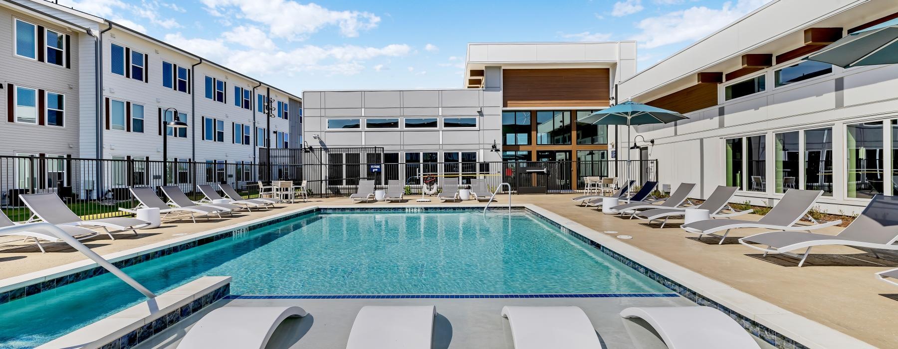 a swimming pool with lounge chairs around it